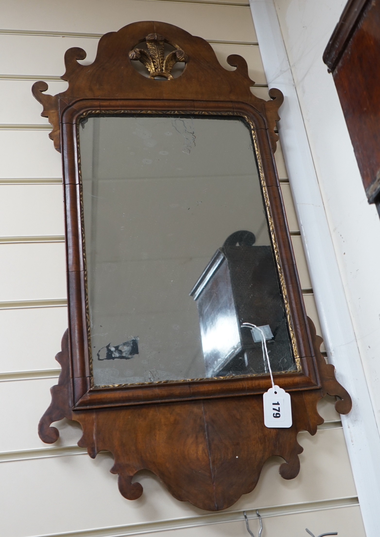 A George III style walnut and parcel gilt fret cut mirror, width 42cm, height 81cm